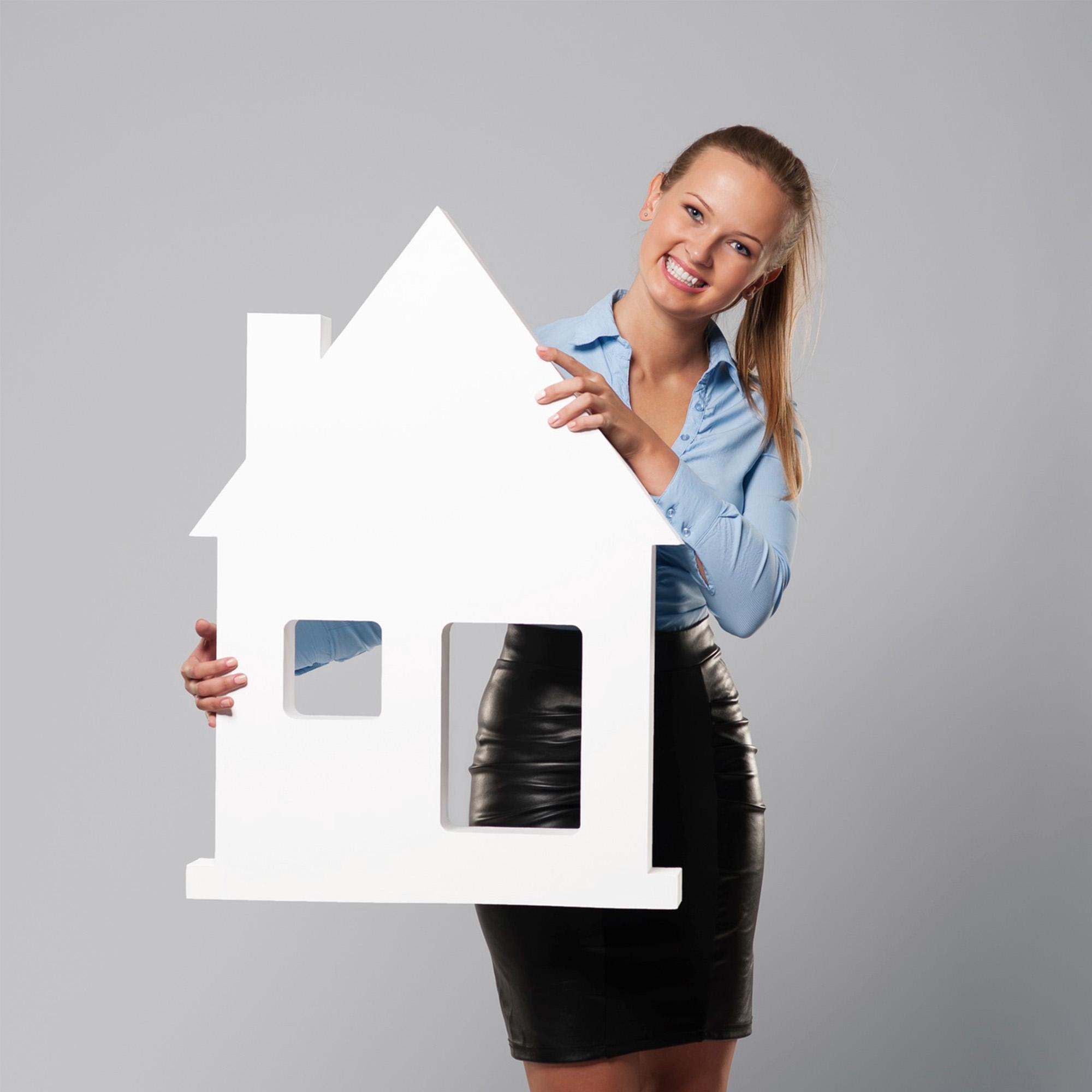 Photo d'une jeune femme tenant une maison en carton blanc pour le visuel de la page de couverture rubrique agence immobilière.