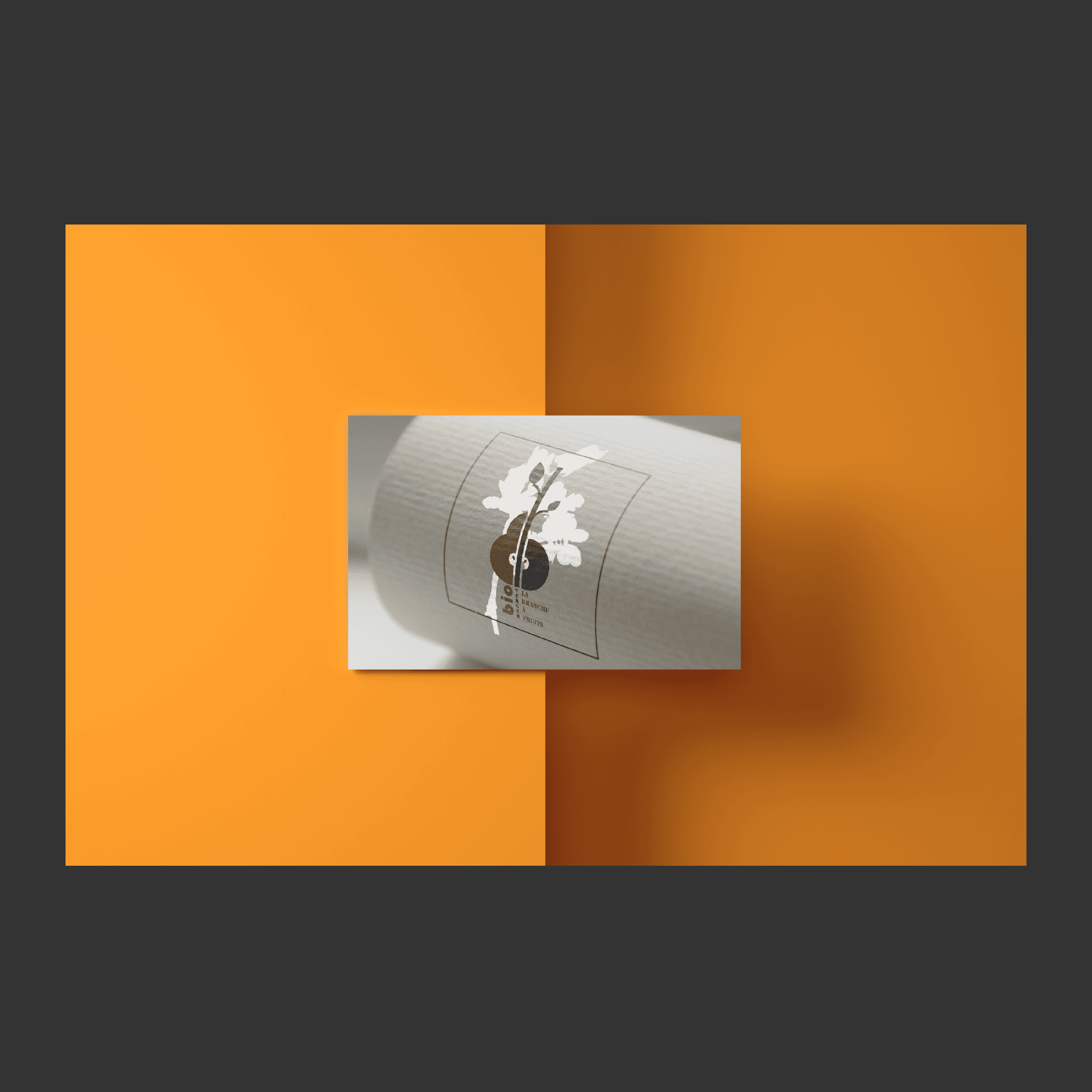 Mockup présentation d'un logo sur une feuille de papier kraft roulée sur un fond orange 